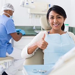 Smiling woman giving thumbs up in treatment chair